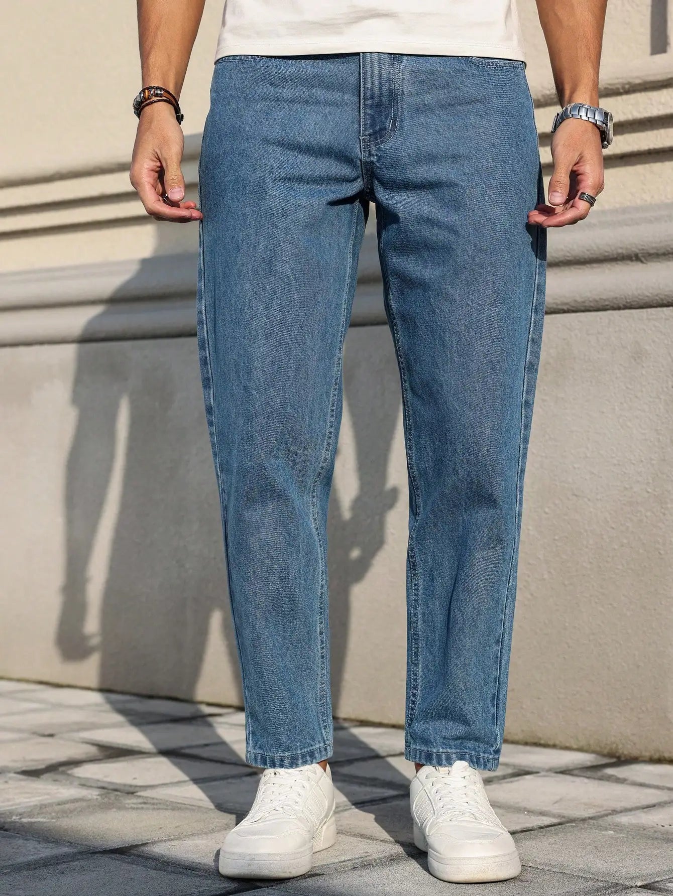 Men's jeans are made of classic blue denim fabric with a loose fit, making them an indispensable versatile item in the wardrobe.